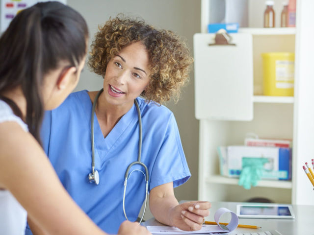 female nurse happily chatting to patient .